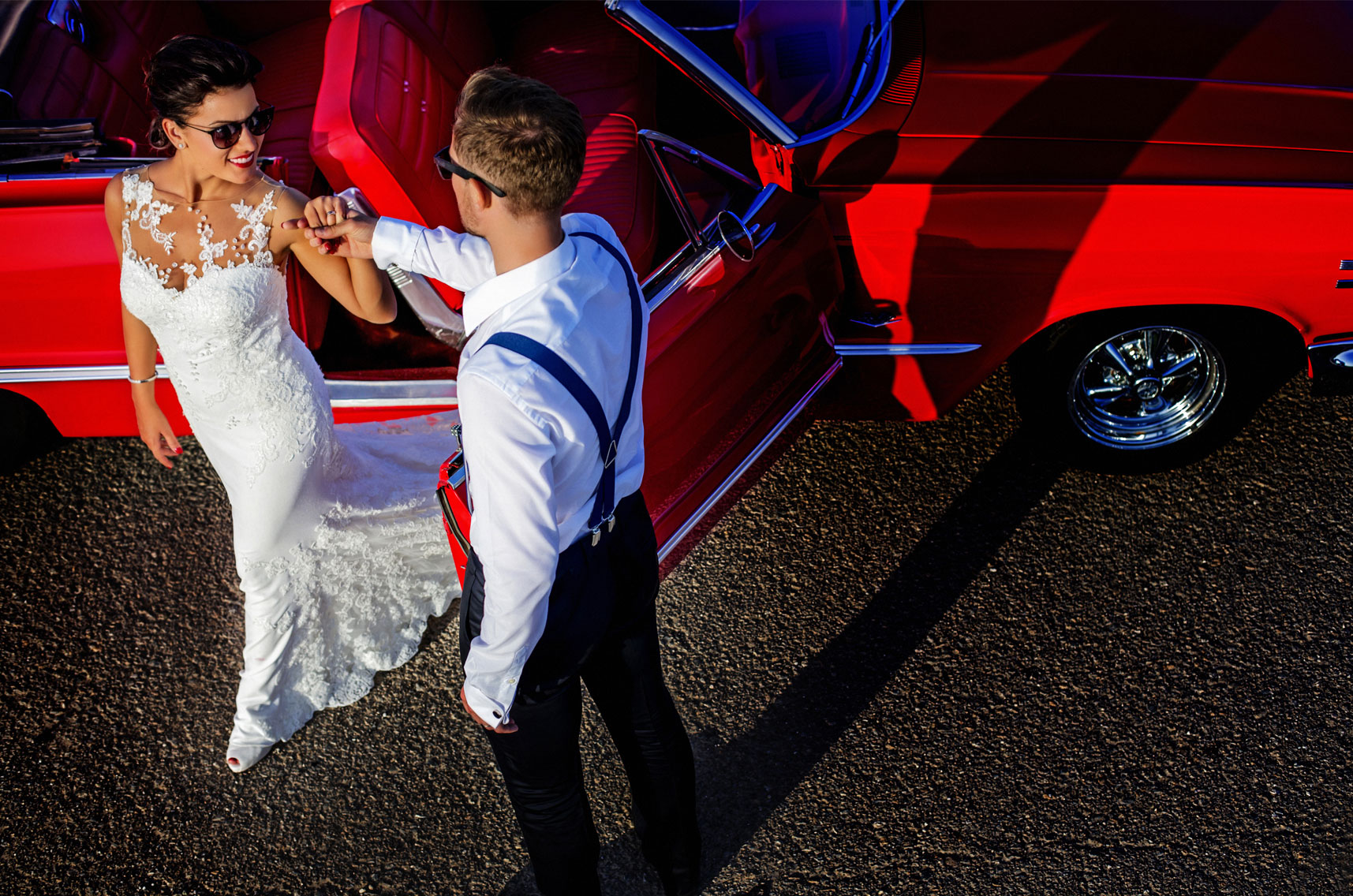 El novio ayudando a la novia a salir del Chevrolet Impala.