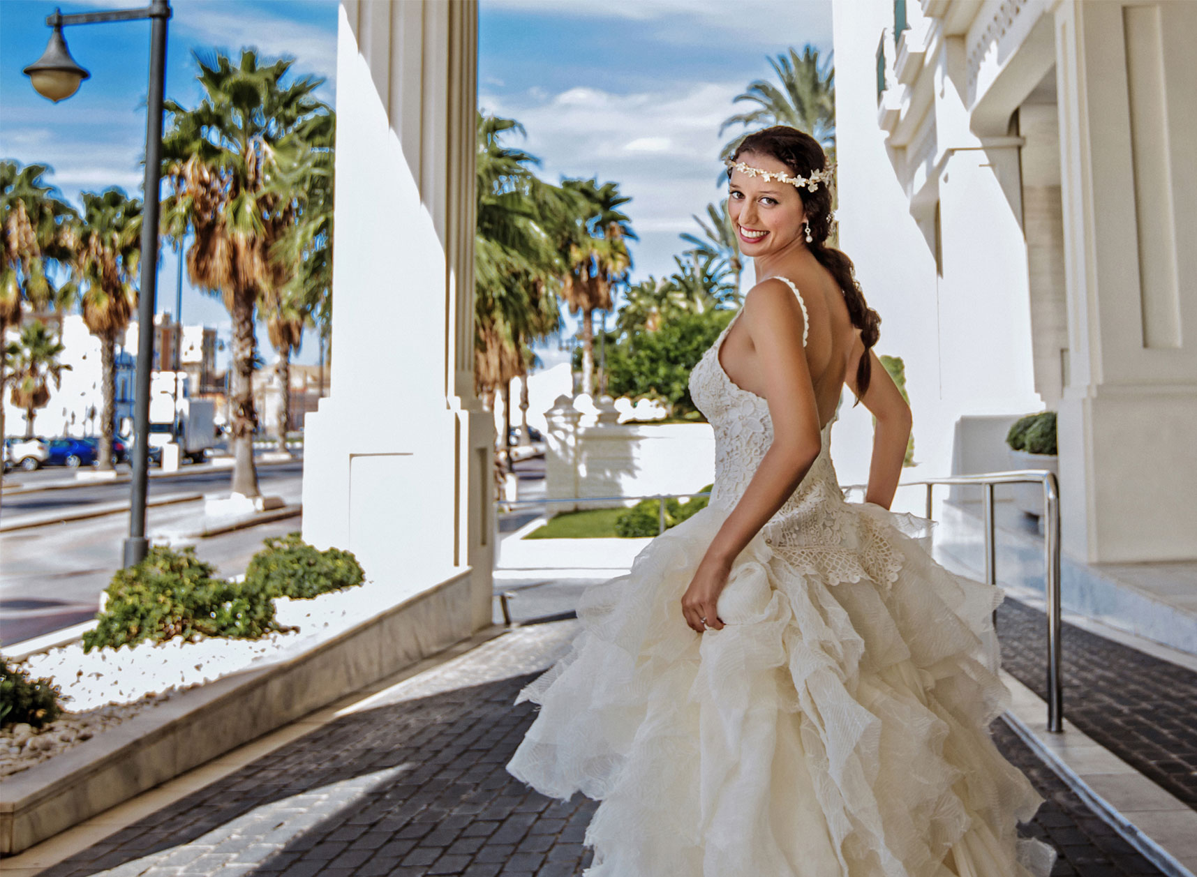 La novia cogiendo su vestido y posando para Ginés López Fotografía de Autor.